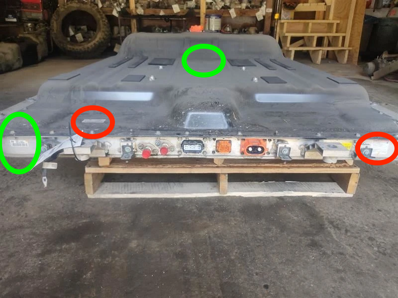 EV battery pack with green circles marking useful label locations and red circles marking labels that are not the part-number label