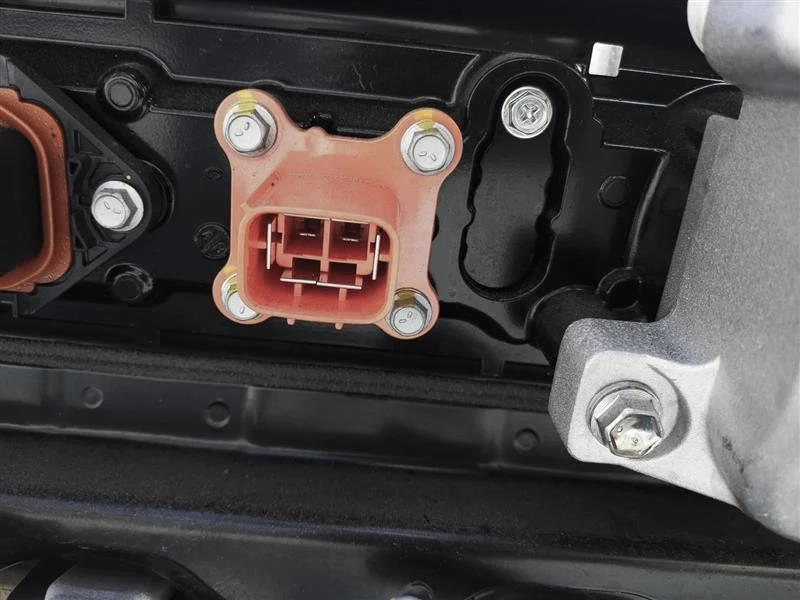 Close view of the orange connector housing, pins, seals, and mounting hardware on a Solterra battery pack