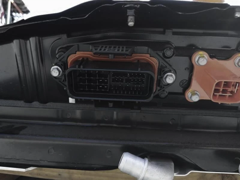 Subaru Solterra EV battery connector face showing the black and orange connector housings